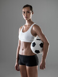 Woman, portrait and soccer player with ball for match, game or kick off on a gray studio background. Female person or athlete with football for sports exercise, workout or training on mockup space