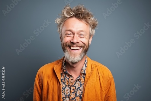 Portrait of a happy senior man smiling at the camera over grey background © Igor