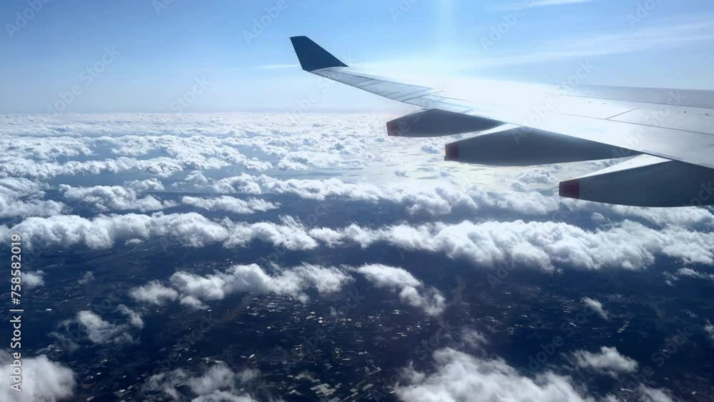 Airplane wing over cloud-covered landscape, sunny skies, distant horizon Airplane wing over cloud-covered landscape, sunny skies, distant horizon