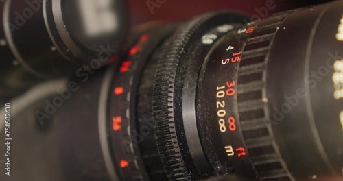 Close-up of the focus and zoom rings of a 16mm film camera lens, which are turned by the cameraman's hand photo