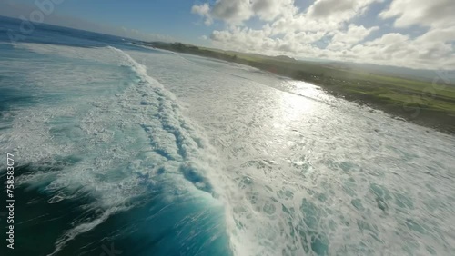 cinematic fpv video of large and powerful waves off the coast of hawaii during a hot and humid summers day just as the sun rises.