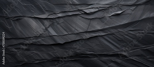 A close up of a damaged black shingle on a roof, showcasing the Wood flooring underneath. The contrasting shades create a striking pattern