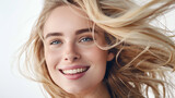 A radiant blonde with a playful and flirty smile, hair billowing in soft light
