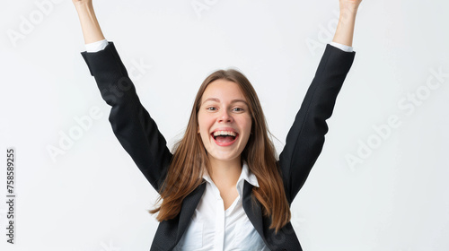 A radiant young woman in black business attire celebrating with arms up on a white background photo