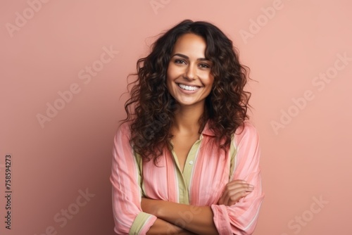 Portrait of a beautiful young woman smiling at the camera over pink background