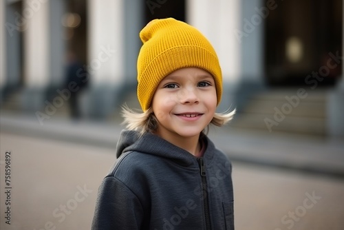 Portrait of a cute little girl in a yellow hat in the city