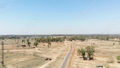 Aerial shot of barren arid land with asphalt road and water at a distance in Charu village in Chatra, Jharkhand, India. photo