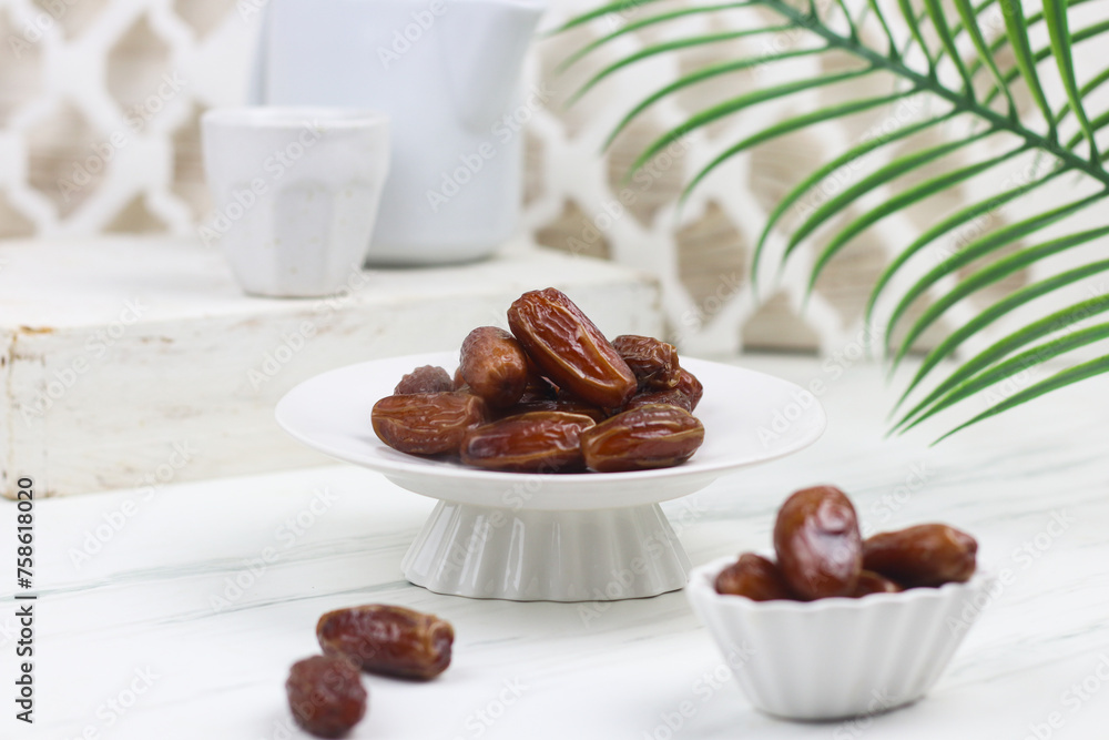 Kurma or Dates fruit on marble white background. Breakfasting concept in Ramadan month. Islamic template for text background. Kurma or Dates fruit on marble white background. Breakfasting concept in Ramadan month. Islamic template for text background.
