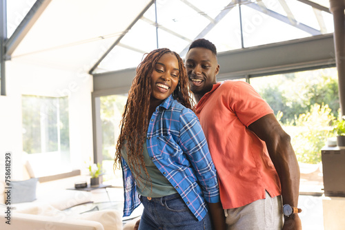 A young African American couple dancing together and smiling at home photo
