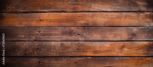 A close up of a brown hardwood plank wall with amber wood stain  showcasing the beautiful tints and shades of the wood grain pattern