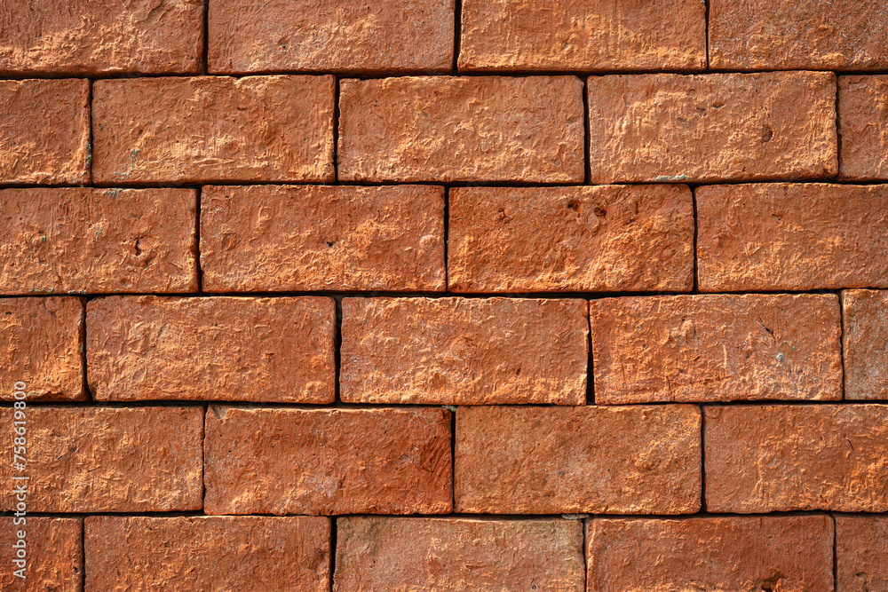 Fototapeta premium Clay brick block wall with roughly surface, close-up and selective focus. background and texture.