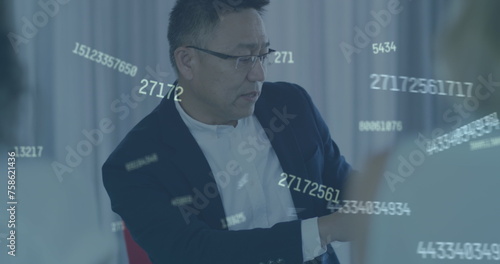 Image of numbers over asian businessman at meeting