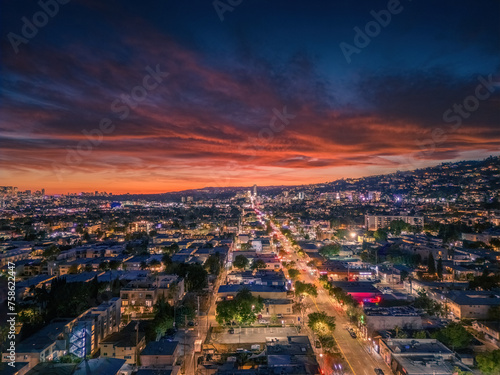 Aerial panorama of city of West Hollywood art dusk. Los Angeles  California. A vibrant sunset blankets the sky with shades of pink and orange  casting a warm glow over a bustling cityscape panorama.
