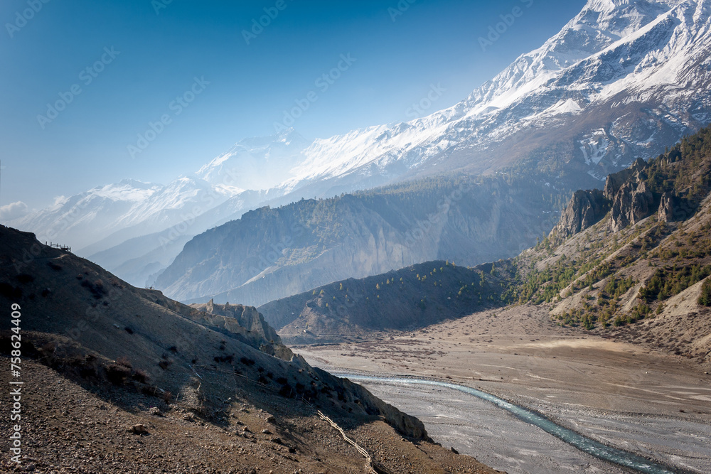 River in the mountains of Nepal against the background of snow-capped mountains and blue sky River in the mountains of Nepal against the background of snow-capped mountains and blue sky