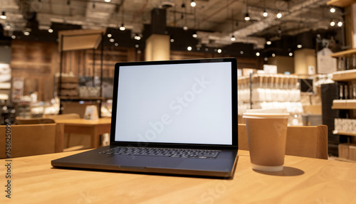 selective focus, laptop with blank screen on wood table in with coffee cafe background.