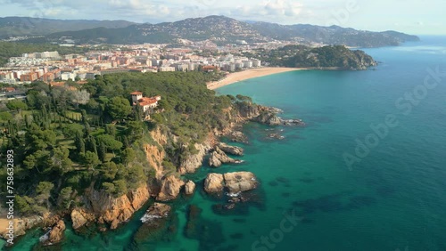 Experience the charm of Lloret De Mar's aerial landscape, featuring its azure sea, sandy beaches, and exclusive sites such as Santa Cristina and Cala Treumal. photo