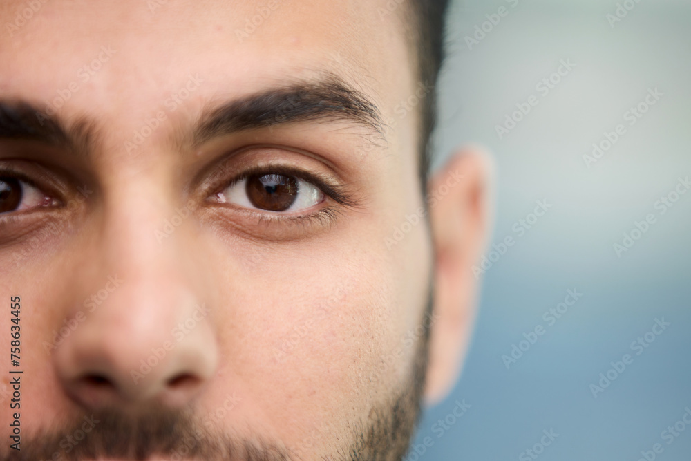 young beautiful man with brown eyes looks at the camera.