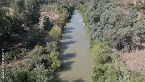 A leisurely drone aerial above the Guadalquivir River in Marmolejo, Jaén province, Spain, showcasing the allure of its natural surroundings and lush scenery. photo