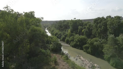 A panning aerial shot over the Guadalquivir River in Marmolejo, Jaén province, Spain, showcasing its natural beauty and lush landscapes. photo