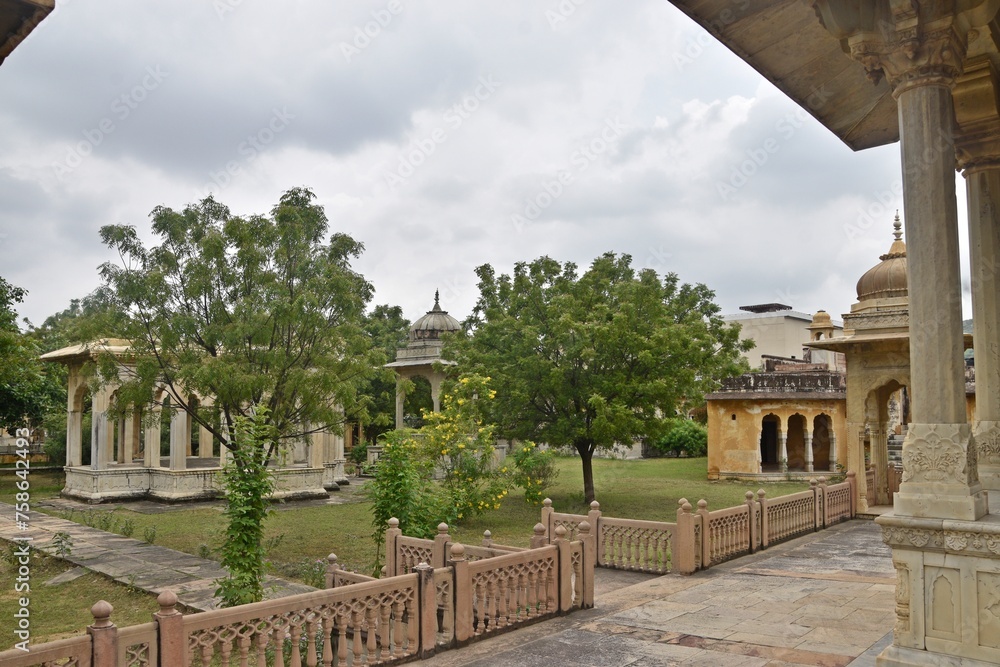 Fototapeta premium Majestic Royal Cenotaphs Amidst Verdant Greenery Under Cloudy Skies at Maharani Ki Chhatri ,Jaipur, Rajasthan, India