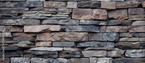 A detailed closeup of a stone wall constructed from a mix of rocks including cobblestones, creating a textured and visually appealing facade