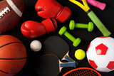 Various sports equipment on black background studio shot