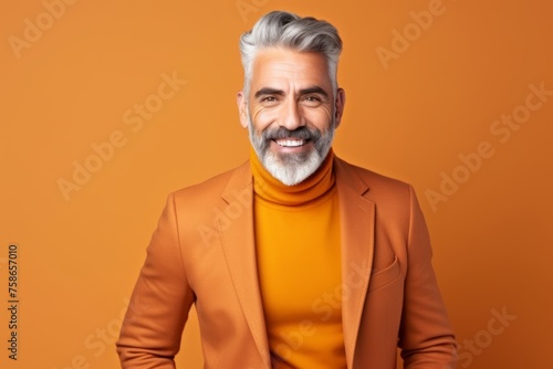 Portrait of happy senior man with grey hair and beard in stylish orange jacket.