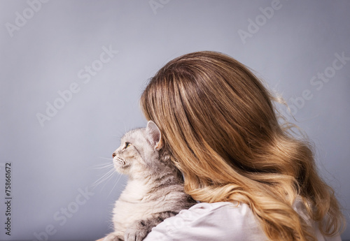 portrait of a pretty girl with a gray cat at home.