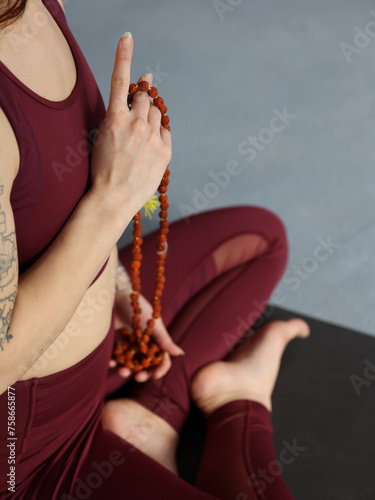 Woman hand holding Rosary beads close up. Yoga, Meditation, Holistic wellness concept.
