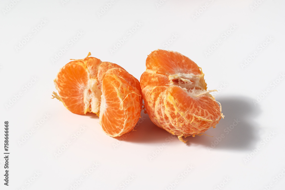 Peeled halves of a ripe tangerine laid out on a white background as a concept of natural vitamins for proper nutrition Peeled halves of a ripe tangerine laid out on a white background as a concept of natural vitamins for proper nutrition
