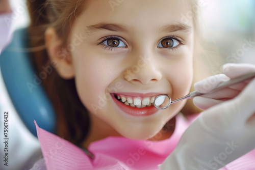 Smiling little girl at dental checkup showing healthy teeth with dentist's mirror