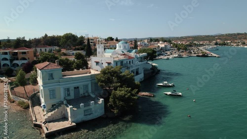 Drone circling around a white Greek building on the coastline of Porto Cheli, medium shot photo