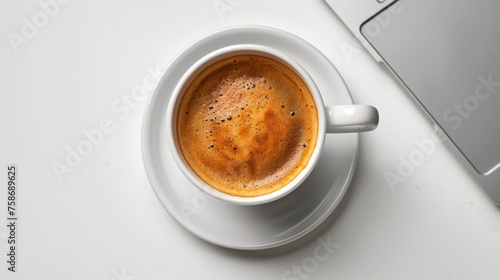 Laptop and coffee cup on white surface. Clean modern desktop. Top view. Room for copy space.