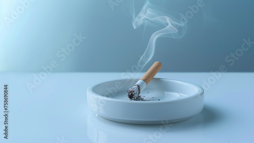 A single lit cigarette in a white ashtray as a stark representation of smoking photo