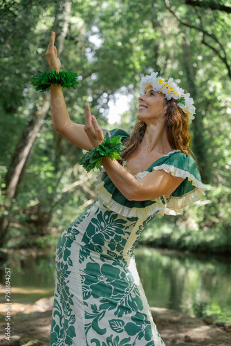 Elegant lady performing Hawaiian hula outside in the jungle environment. Concept of Polynesian artistic traditions. Sensation of joy and celebration.