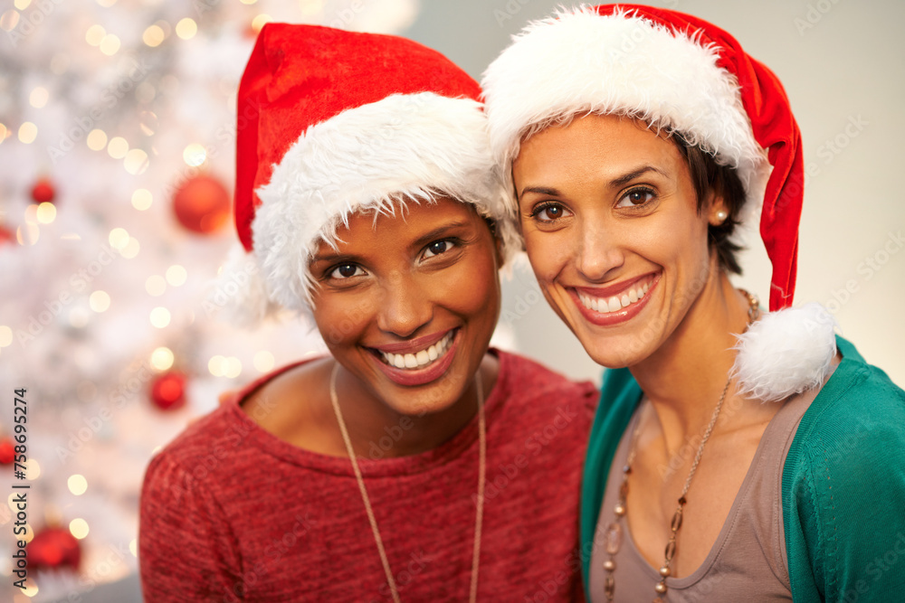 Friends, hat and portrait by Christmas tree in home, smile and excited for festive season. Women, religious holiday and ready for celebration in living room, happy and traditional fashion on vacation Friends, hat and portrait by Christmas tree in home, smile and excited for festive season. Women, religious holiday and ready for celebration in living room, happy and traditional fashion on vacation