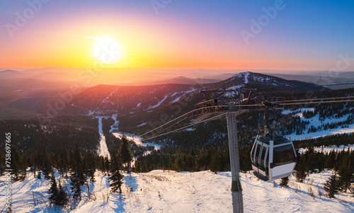 Aerial top view landscape ski lift resort with snowy forest on mountain in winter sunlight, Sheregesh, Kemerovo region Russia