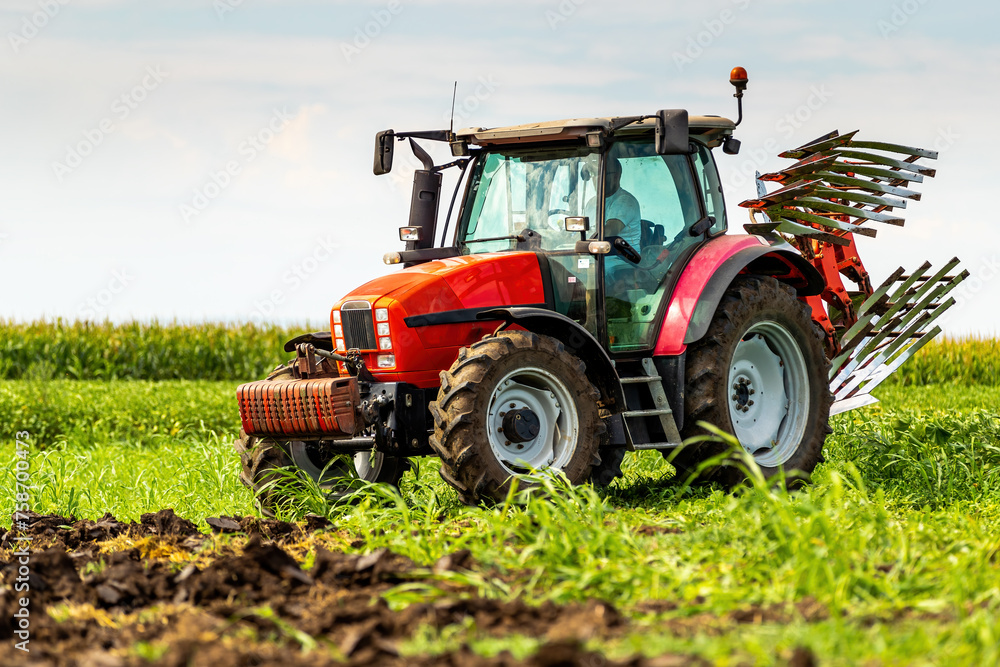 Agricultural tractor tilling fertile soil, readying the field for sowing Agricultural tractor tilling fertile soil, readying the field for sowing