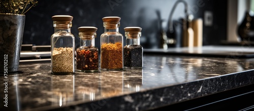 Close-up image of spice bottles on a luxurious black marble kitchen countertop in a modern kitchen