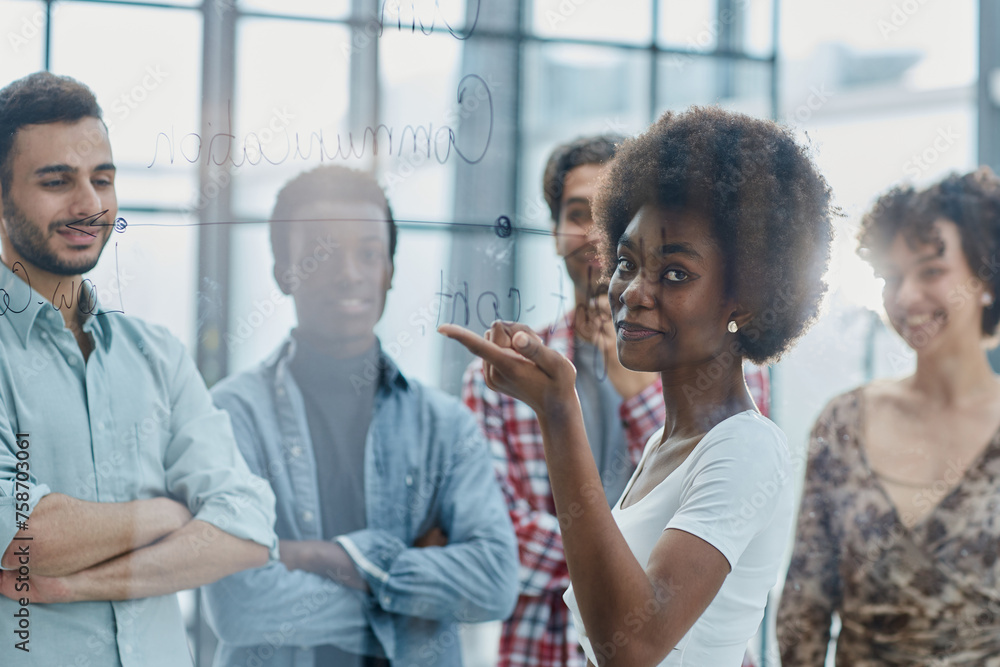 Obraz premium a team of young designers sticking notes on glass in a modern office