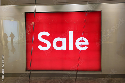 Red sale sign in shop window.