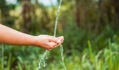 water pouring flow on woman hand on nature background