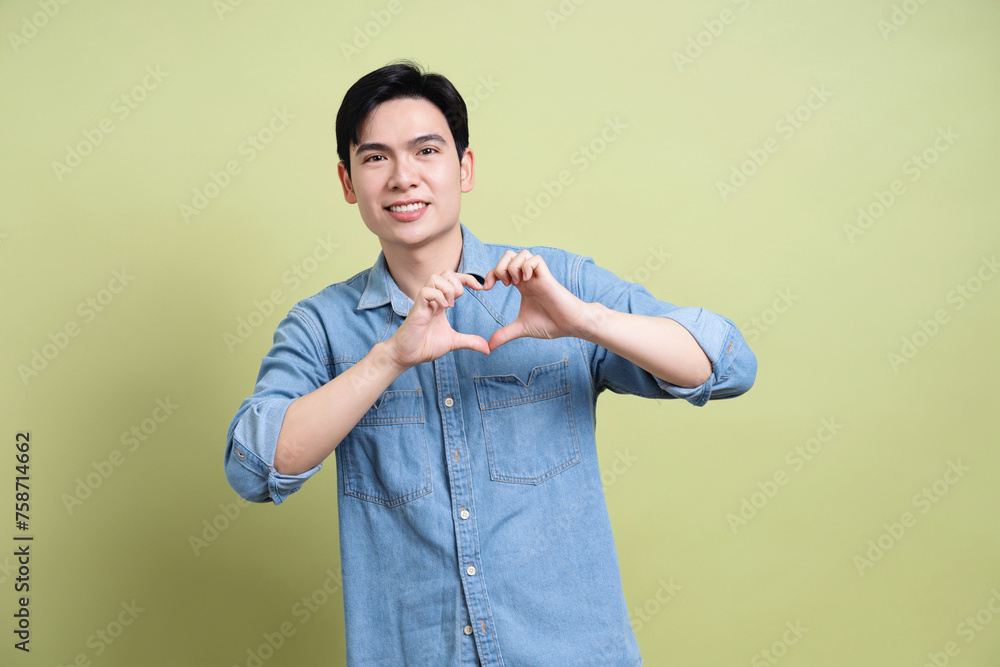 Photo of young Asian man on green background Photo of young Asian man on green background