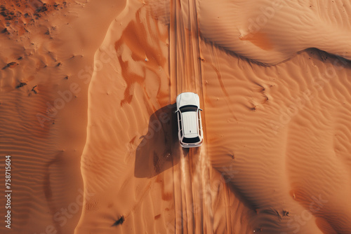 aerial view captures a white SUV driving through a vast deser