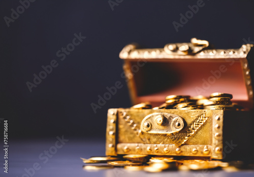 Close up Open treasure chest filled with gold coins on dark background