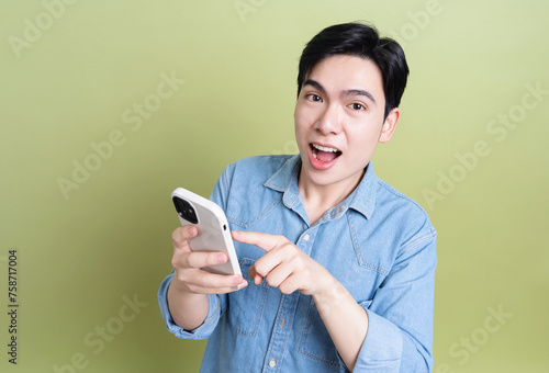 Photo of young Asian man on green background