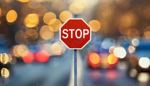 Stop road sign. Red octagon with white lettering. Blurred bokeh on background.