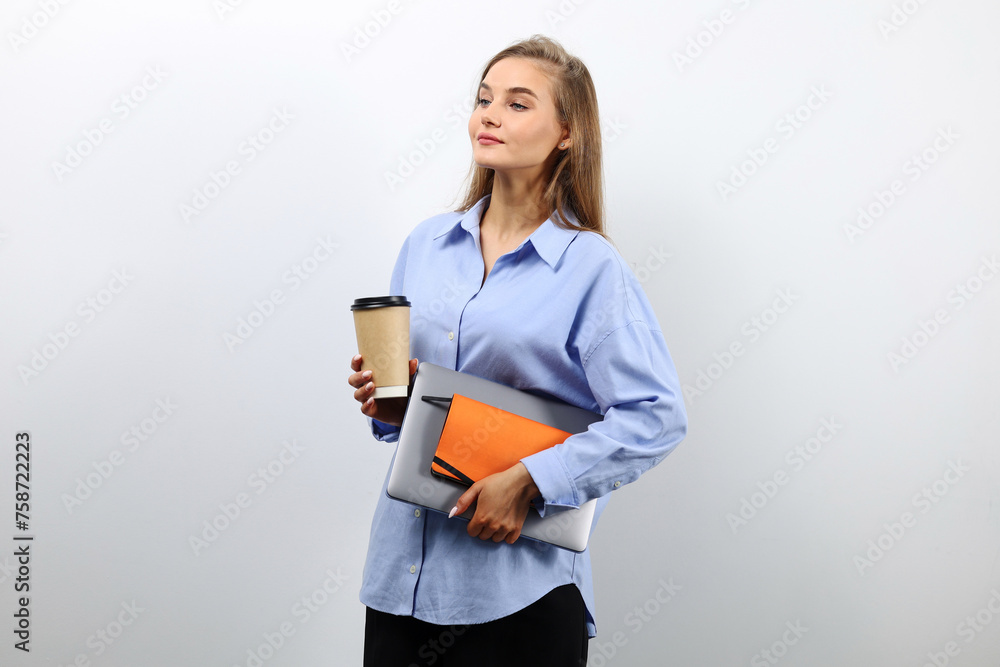 European woman with blue shirt with laptop and cup of coffee, business concept European woman with blue shirt with laptop and cup of coffee, business concept