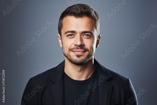 Portrait of a handsome young man in a black jacket. Studio shot.