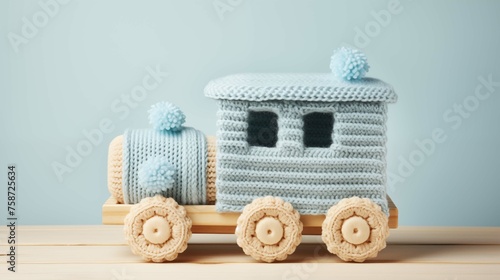 Handmade knit train toy in pastel colors image background. Plaything on wooden surface close up picture wallpaper. Childhood nostalgia closeup photo backdrop. Babyhood concept photography